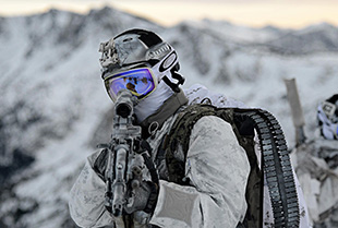 A team of United States Navy Seals in full gear works together during a spec ops training session.