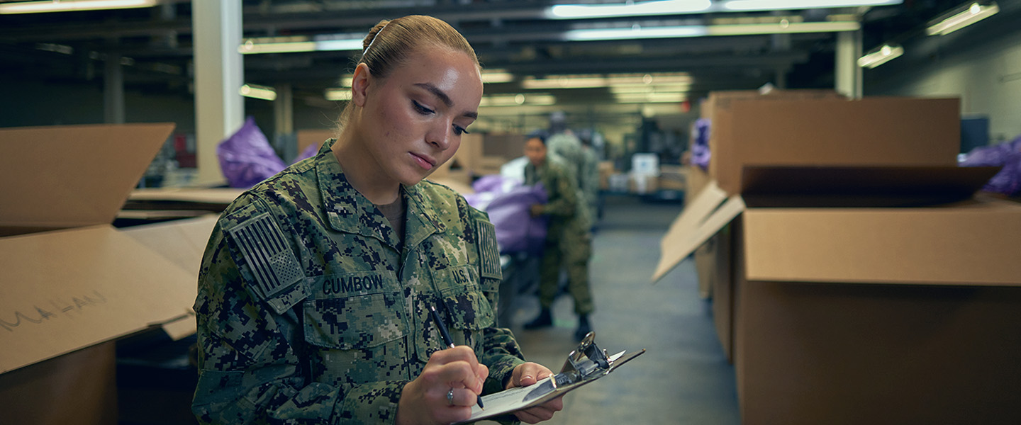 A Navy Sailor takes inventory of essential supplies in a ship's storage area.