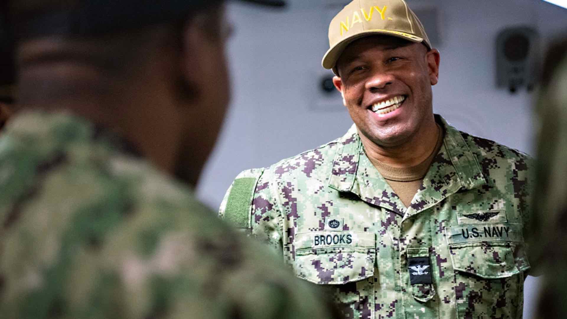 A Navy Sailor smiles at his colleague.