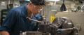 A United States Navy Machinery Repairman operates a milling machine aboard the USS Chung-Hoon.