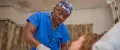 Navy nurse listening to a patient's heartbeat with a stethoscope during a medical checkup.