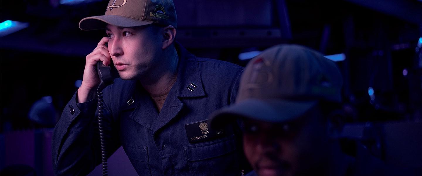 A U.S. Navy Sailor makes a call aboard a ship during a mission.
