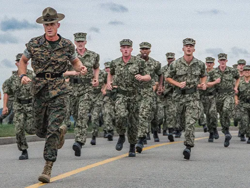 A Marine drill instructor leads Navy Officer Candidate School students through physical training at Officer Training Command Newport.