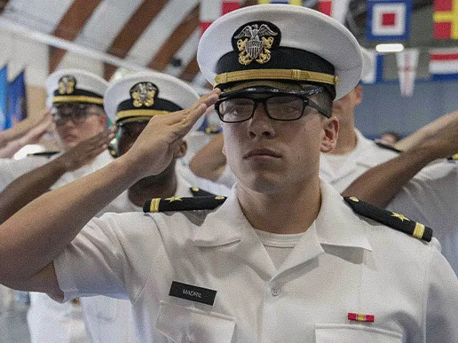 Officer Candidate School graduates salute in formation during a Navy graduation ceremony.